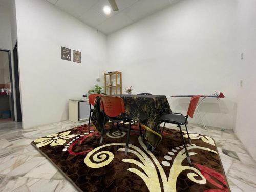 居銮My Delima Home for MusIim的一间设有两把椅子、一张桌子和地毯的房间