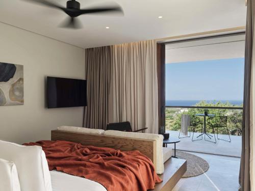 VourvoúlosMagma Resort Santorini, In The Unbound Collection By Hyatt的一间卧室设有一张床,享有阳台的景色