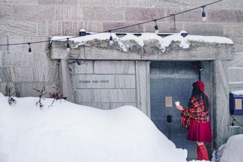 小樽石と鉄-House of STONE and IRON的站在雪中门前的女人