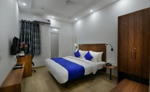 加济阿巴德Hotel The Emporio A Corporate Suites的一间卧室配有一张带蓝色枕头的大床