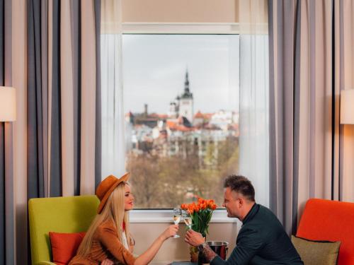 塔林维鲁所库斯经典酒店的坐在鲜花房里的男人和女人