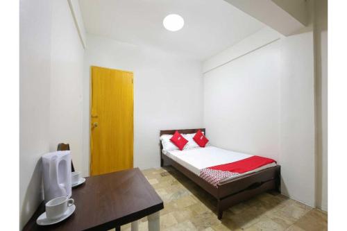 马尼拉OYO 1069 Cittatel Inn的一间小卧室,配有一张床和一张书桌