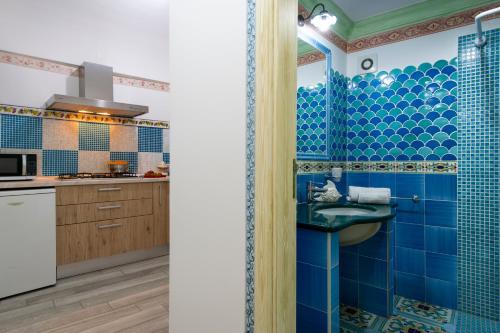 波西塔诺Amore Rentals - Casa Barbera B的蓝色瓷砖浴室设有水槽和厨房