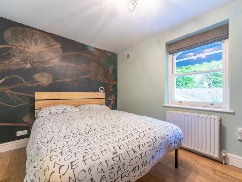 SurbitonSurbiton Garden Flat的卧室配有一张床,墙上挂有绘画作品