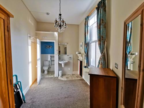 彭赞斯Treventon Guest House的一间带水槽、卫生间和吊灯的浴室