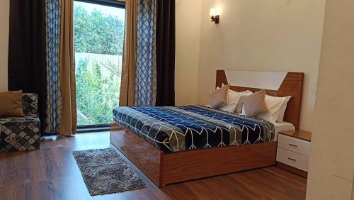 BahoraAroma Green Resort的一间卧室设有一张床和一个大窗户