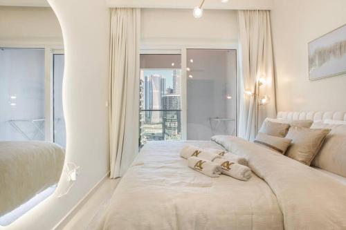 迪拜Luxe Den-1BR Cozy Treat By Canal side的白色卧室配有一张大床和两个枕头