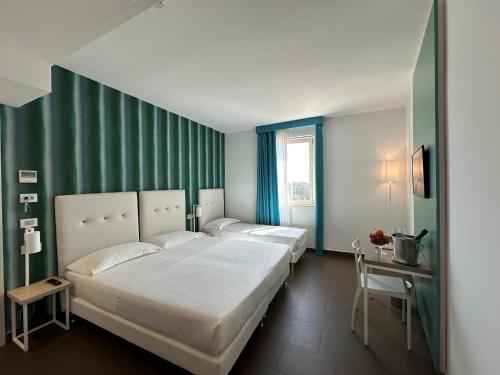 陶尔米纳伊尔皮克罗贾迪诺GH***高级酒店的卧室设有两张床铺和绿色的墙壁