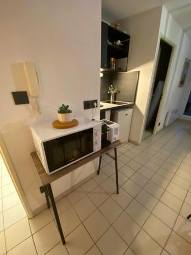 Saint-Orens-de-GamevilleTerracotta - Cosi - WIFI - Parking - Terrasse的带微波炉的厨房(桌子上)
