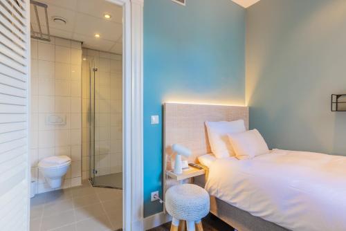 莱顿City Hotel Rembrandt的一间卧室设有一张床、淋浴和卫生间