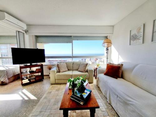 埃斯特角城APARTAMENTO VISTA MAR en la PENÍNSULA de PUNTA del ESTE的带沙发、桌子和电视的客厅