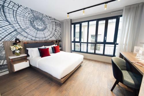 巴黎Mode Paris Aparthotel的卧室配有带红色枕头的白色床
