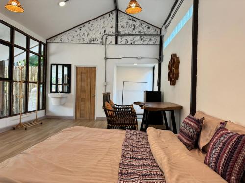 清迈Proud Chiang Mai Poshtel的一间卧室配有一张大床和一张桌子