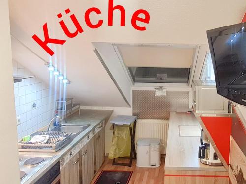 罗登巴赫Hotel Garni Rodenbach的一间带水槽的小厨房和一台电视