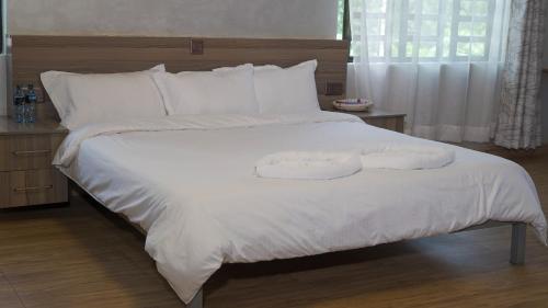 EmbuEmbu Pazuri Homes的一张白色的大床,带两条毛巾