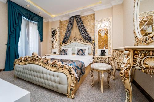 第比利斯Hotel Aqua Liberty的一间卧室配有一张特大号床,配有蓝色和金色家具