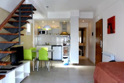 布宜诺斯艾利斯巴提蒙公寓的厨房以及带桌子和绿色椅子的客厅。