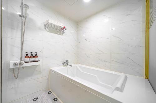 庆州Number 25 Gyeongju City Hall的白色的浴室设有浴缸和水槽。