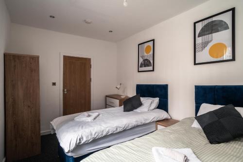 曼彻斯特England's Cozy 1-Bed room Room 1的一间卧室配有两张带蓝色椅子的床