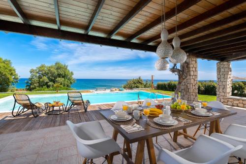 拉卡尼亚Villa Sevil的一个带桌椅的庭院和一个游泳池