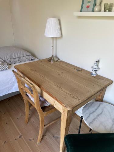 瓦伊比Cutest annex - close to Heatherhill and sea :-)的一张木桌,床上有台灯