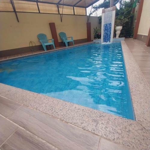 宿务Eli's Villa Cebu的一个带蓝色椅子的大型游泳池