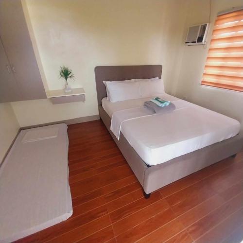宿务Eli's Villa Cebu的卧室配有白色的床和窗户