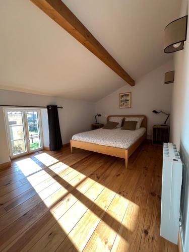 Saint-SauveurChâteau La Fon du Berger的一间卧室配有一张床,铺有木地板