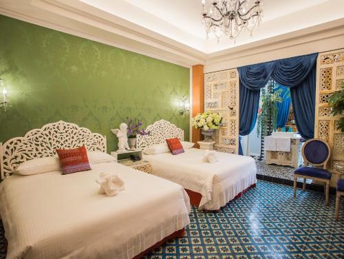 嘉义市安娜与国王酒店的绿墙客房的两张床