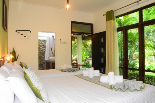 达瓦拉维Leel’s Safari Cottage的卧室配有带白色枕头的大床