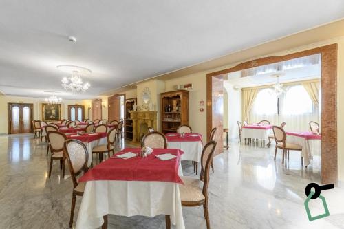 奥尔比亚HOTIDAY Hotel Olbia的一间设有红色桌椅的用餐室