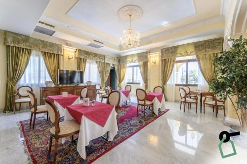 奥尔比亚HOTIDAY Hotel Olbia的一间带桌椅和电视的用餐室