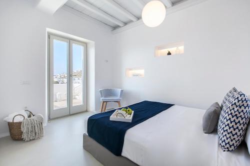 普拉迪斯亚罗斯Breathtaking 6 Bed in Platis Gialos的卧室配有床、椅子和窗户。