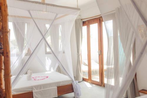南威Bukoba Villas - Olive - Private Pool, AC & Wi-Fi的一间卧室配有一张天蓬床和窗户