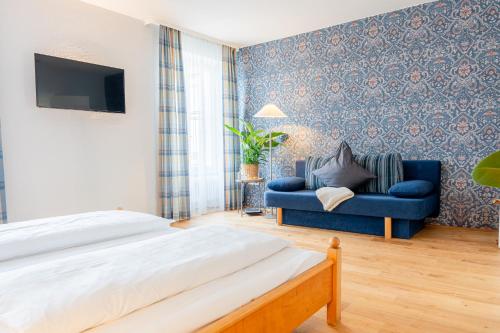 穆尔海姆Biohotel Alte Post的一间卧室配有一张床和一张蓝色的沙发