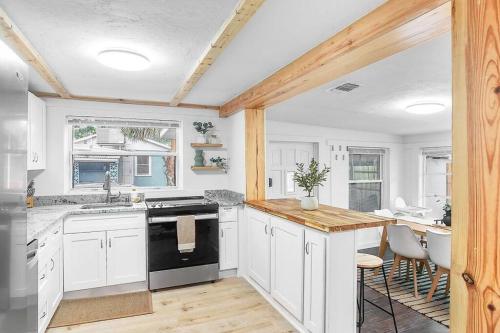 维洛海滩Central, Cozy Retreat的厨房配有白色橱柜和黑炉灶烤箱。