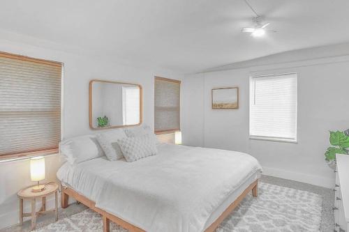 维洛海滩Central, Cozy Retreat的一间白色卧室,配有床和2个窗户