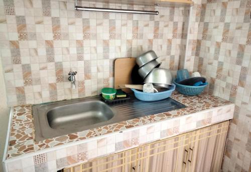 奈瓦沙M&M HOMES的厨房柜台配有水槽和餐具