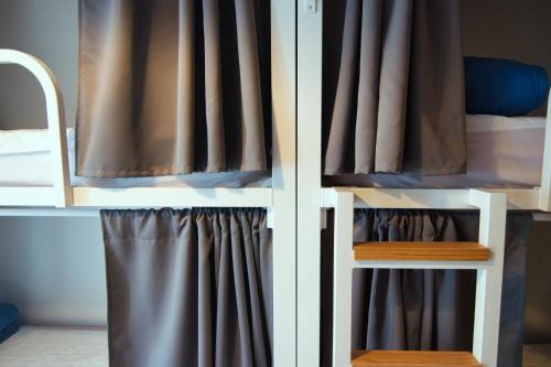 巴塞罗那Factory Hostels Barcelona的一间卧室配有带窗帘的双层床