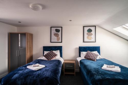 曼彻斯特Refined Comforts for Two Room 5的一间设有两张床铺和毛巾的房间