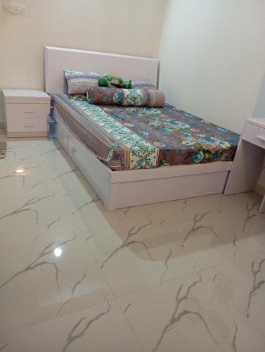 瓦度Aaraasth的卧室配有1张床,铺有瓷砖地板。