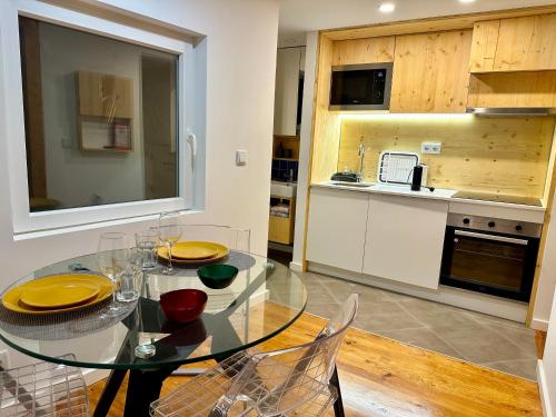 里斯本Castle cozy apartment的厨房里设有1间带玻璃桌和椅子的用餐室