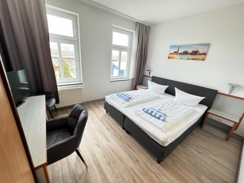 罗斯托克Appartement-Hotel Rostock的一间卧室配有一张床和一把椅子