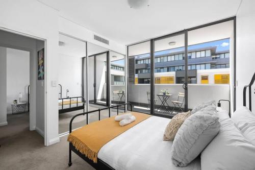 悉尼NEW 3BR Apt in Kingsgrove Sleeps 7的一间带大床的卧室和一个阳台