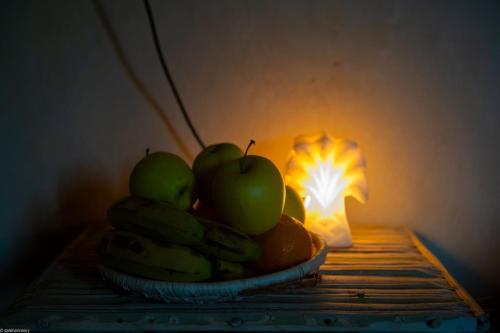 锡瓦Siwa Palace Lodge的灯旁一碗苹果和香蕉