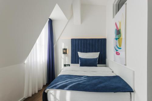 柏林Homaris East Side Hotel - Mobile Key Access的一间小卧室,配有蓝色和白色的床