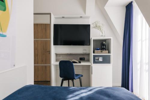 柏林Homaris East Side Hotel - Mobile Key Access的一间卧室配有一张床和一张书桌及电视