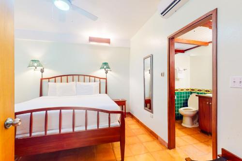 珀拉什奇亚Condo #25 @ Beachside Villas的一间卧室配有一张床和一个卫生间