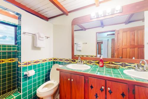珀拉什奇亚Condo #25 @ Beachside Villas的一间带卫生间、水槽和镜子的浴室