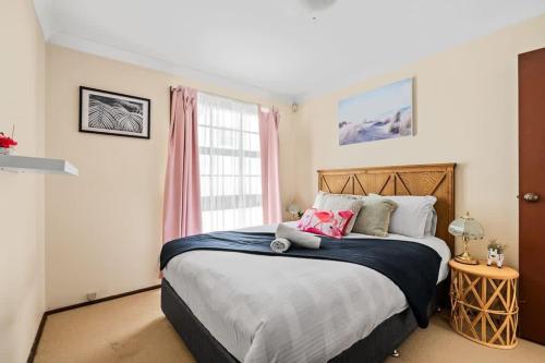 悉尼Beautiful Home In Milperra Sleeps 8的一间卧室设有一张大床和一个窗户。